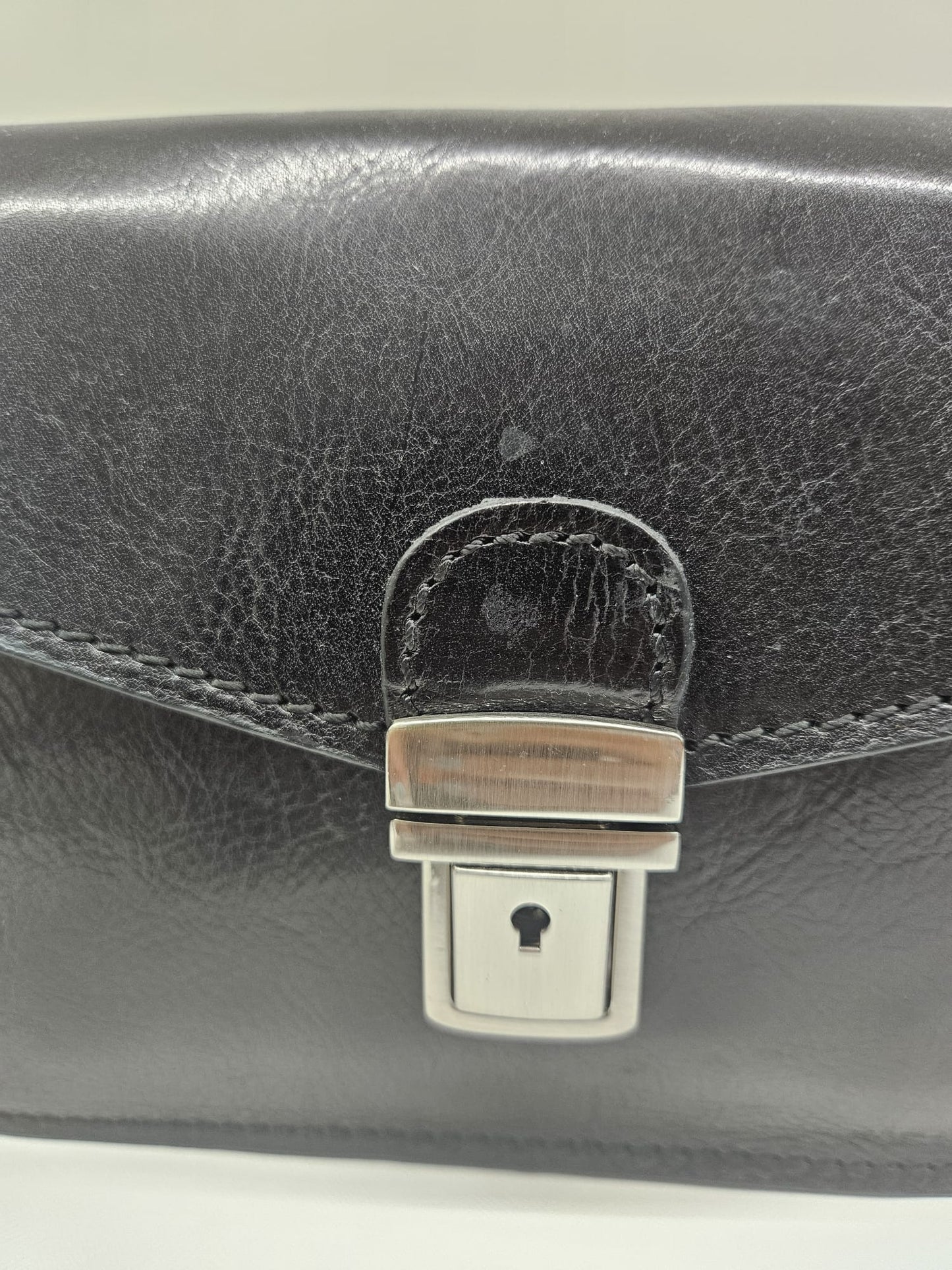 Borsello a mano uomo in pelle vacchetta con chiusura clips in metallo.